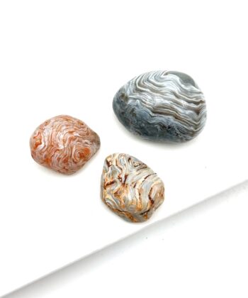 Polerede sten i gyldne og grå toner med hvidlige lag