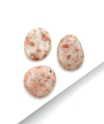 Polerede hvidlige sten med lyserøde aftegninger