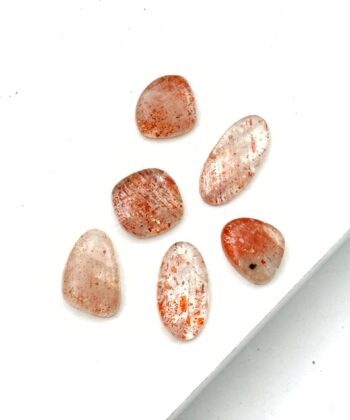 Polerede lyserøde sten med koralfarvede detaljer
