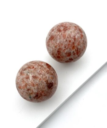 Polerede stenkugler i rødlige farver