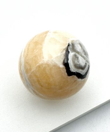 Gul calcit m. sort kugle på hvid baggrund