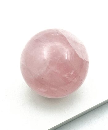 lyserød rosenkvarts kugle på hvid baggrund