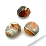 Grå og orangebrune polychrome jaspis krystaller på hvid baggrund