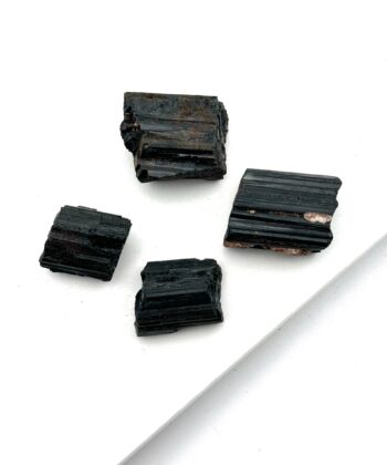 Sorte rå krystaller på hvid baggrund