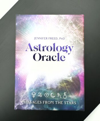 cover til orakelkort med stor lilla skrift og universet i baggrunden med planet og hvidt lys