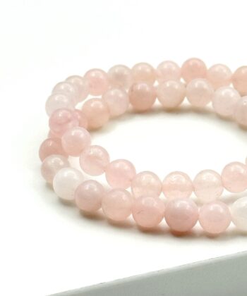 Let lyserøde armbånd på hvid baggrund