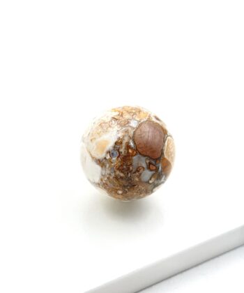 Beige og brun krystalkugle på hvid baggrund
