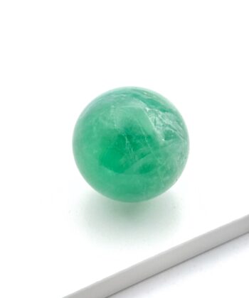 Grøn krystalkugle på hvid baggrund