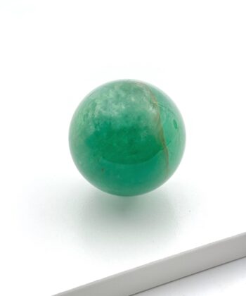 Grøn krystalkugle på hvid baggrund