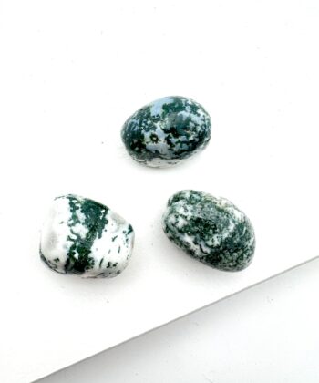 Hvid og mørkegrønne afrundede krystaller på hvid baggrund