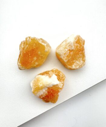 Rå orangegule krystaller på hvid baggrund