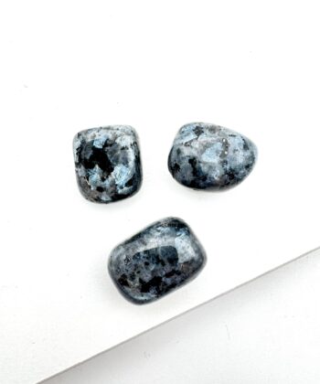 grå og sorte afrundede krystaller på hvid baggrund