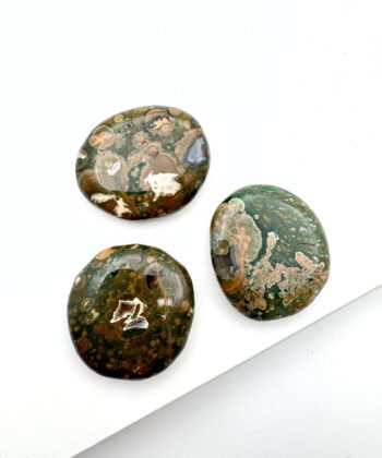 Jordgrønne flade krystaller på hvid baggrund