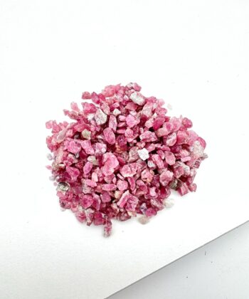 Lyserøde rå krystaller på hvid baggrund