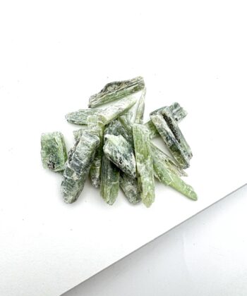 Lyse- og mørkegrønne rå krystaller på hvid baggrund