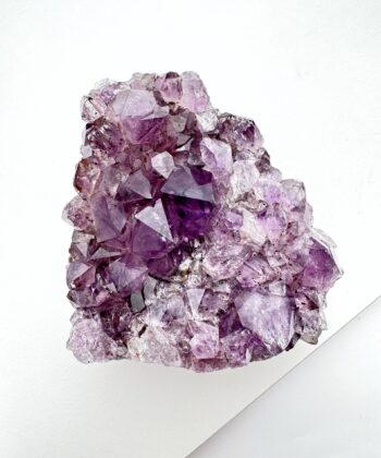 Lilla druzy ametyst krystal på hvid baggrund