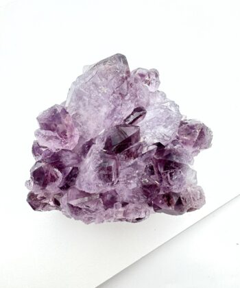 Lilla druzy ametyst krystal på hvid baggrund