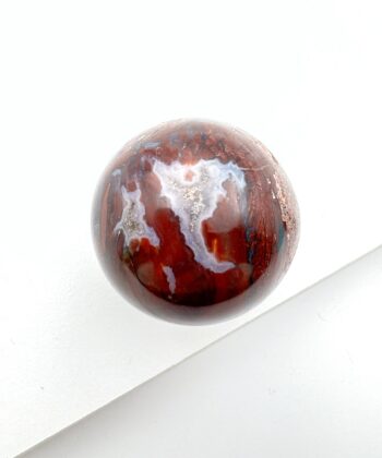 Jordrød og grå krystalkugle på hvid baggrund