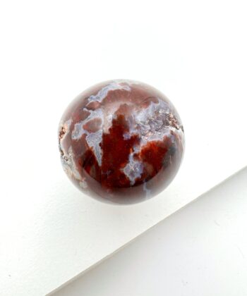 Jordrød og grå krystalkugle på hvid baggrund