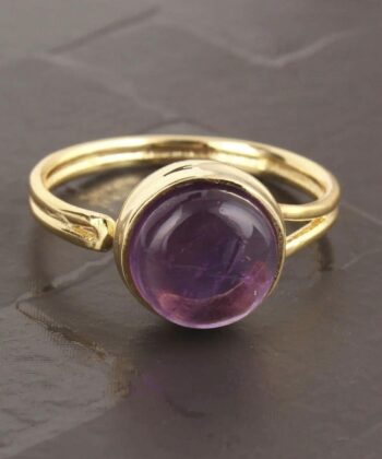 Justerbar ring med lilla halvædelsten på grå baggrund