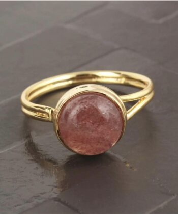 Justerbar ring med rosa halvædelsten fotograferet på grå baggrund