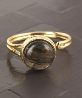 Justerbar ring med smuk halvædelsten fotograferet på grå baggrund