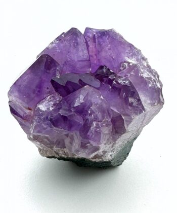 Lilla druzy ametyst krystal på hvid baggrund