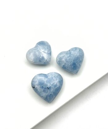 Lyseblå hjertekrystaller på hvid baggrund