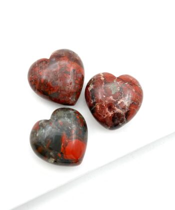 Jordrøde og grå hjertekrystaller på hvid baggrund