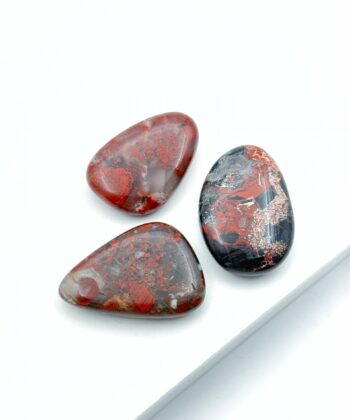 Jordrøde og sorte lommesten på hvid baggrund