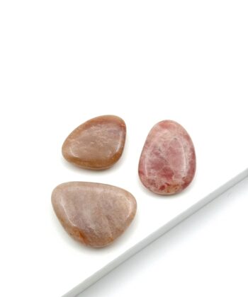 Sandfarvede og let lyserøde lommesten på hvid baggrund