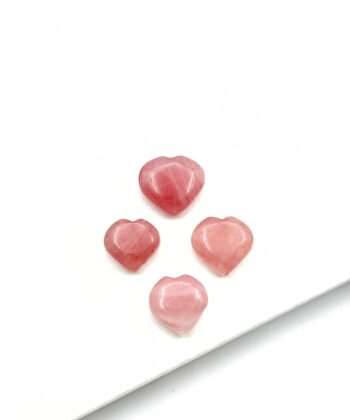 Lyserøde hjertekrystaller på hvid baggrund