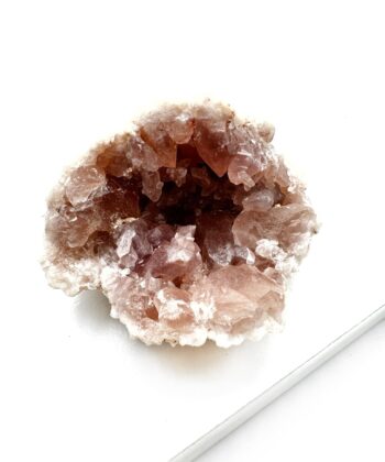 lyserødt druzy rå krystalstykke på hvid baggrund