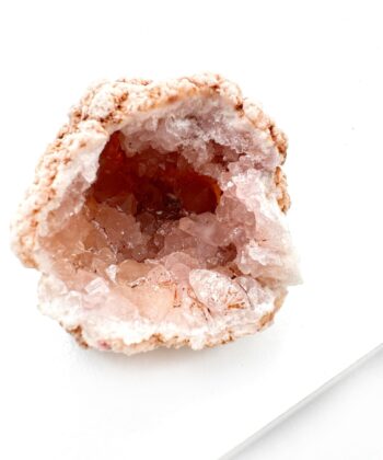 lyserødt druzy rå krystalstykke på hvid baggrund