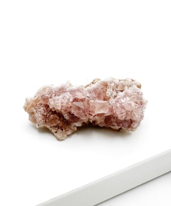 lyserødt druzy rå krystalstykke på hvid baggrund