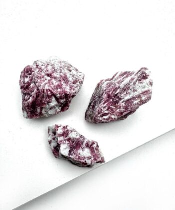 lyserøde og hvide rå stykker krystal på hvid baggrund