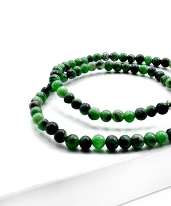 Armbånd med grønne og sorte kugler på hvid baggrund