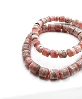 Lakse farvet Lyserød og hvidgrålige blonder Rhodocrosit korte cylinder poleret perle armbånd på hvid baggrund
