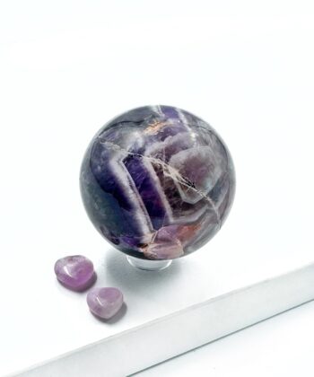 Mørke lilla med hvide blonde farver ametyst kugle rund poleret på hvid baggrund