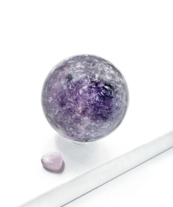 Mørk og lyse lilla lepidolit krystal kugle rund glat poleret på hvid baggrund