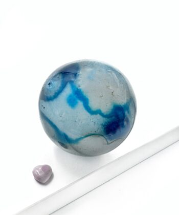 Mørkeblå og blågrå farvet agat kugle rund poleret på hvid baggrund