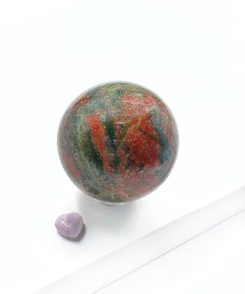 Grøn rødlig nuanceret unakit kugle poleret rund på hvid baggrund