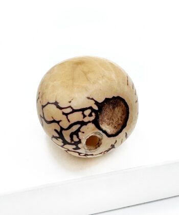 Mild gullig hvid poleret lommesten krystal med sort plet og mønster på hvid baggrund