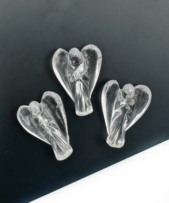 Tre klare bjergkrystal engle figurer på sort plade på hvid baggrund