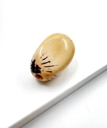 Mild gullig hvid poleret lommesten krystal med sort plet og mønster på hvid baggrund