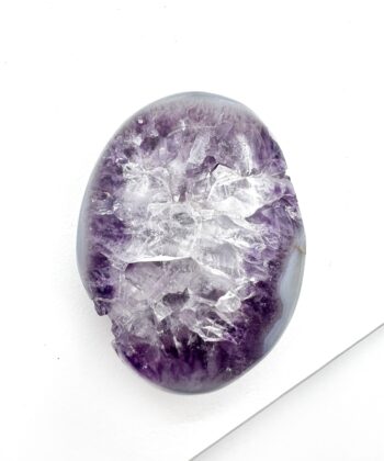 Lilla ametyst med tydelig hvide kvarts i midten oval poleret på hvid baggrund