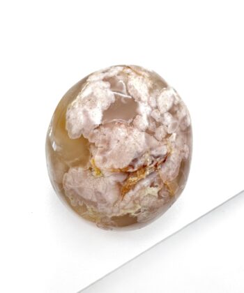 Varm sandfarvet blomster agat oval poleret med naturlige revner i på hvid baggrund