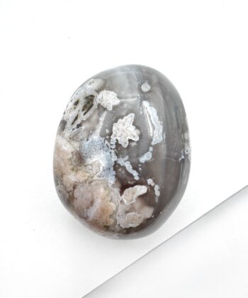 Grålig blomster agat oval poleret på hvid baggrund