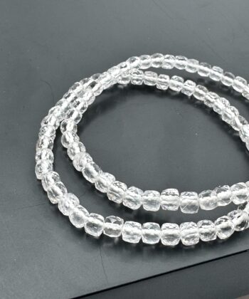 Armbånd med lyse klare krystalsten facetslebet perler på mørk baggrund