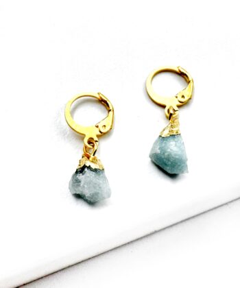 Øreringe med rå lys blå krystal på hvid baggrund